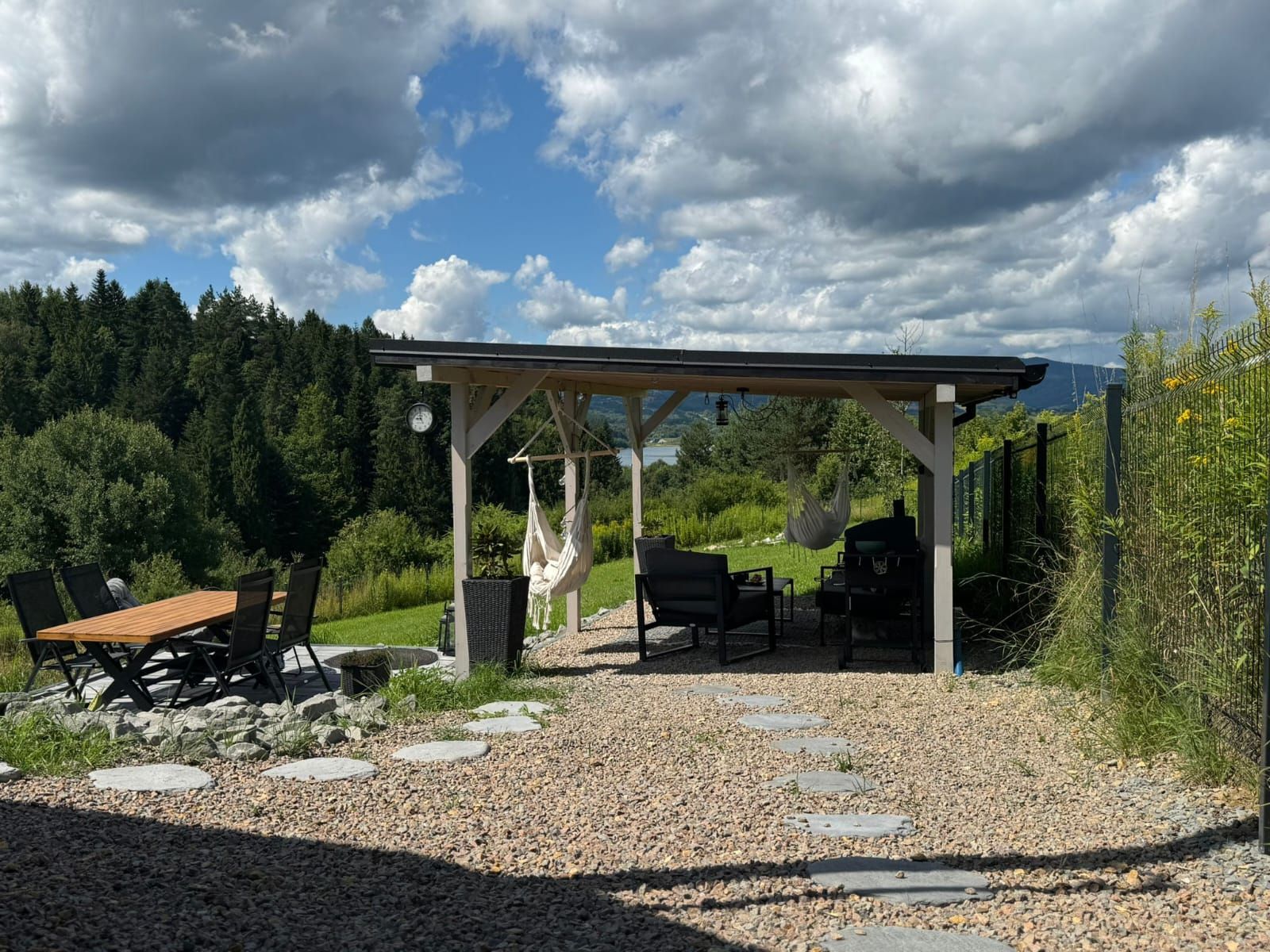 Pergola z hamakami i stołem, w tle las